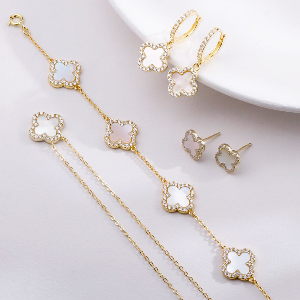 14k Gold clover jewelry set with necklace, earrings, and ring on a white background