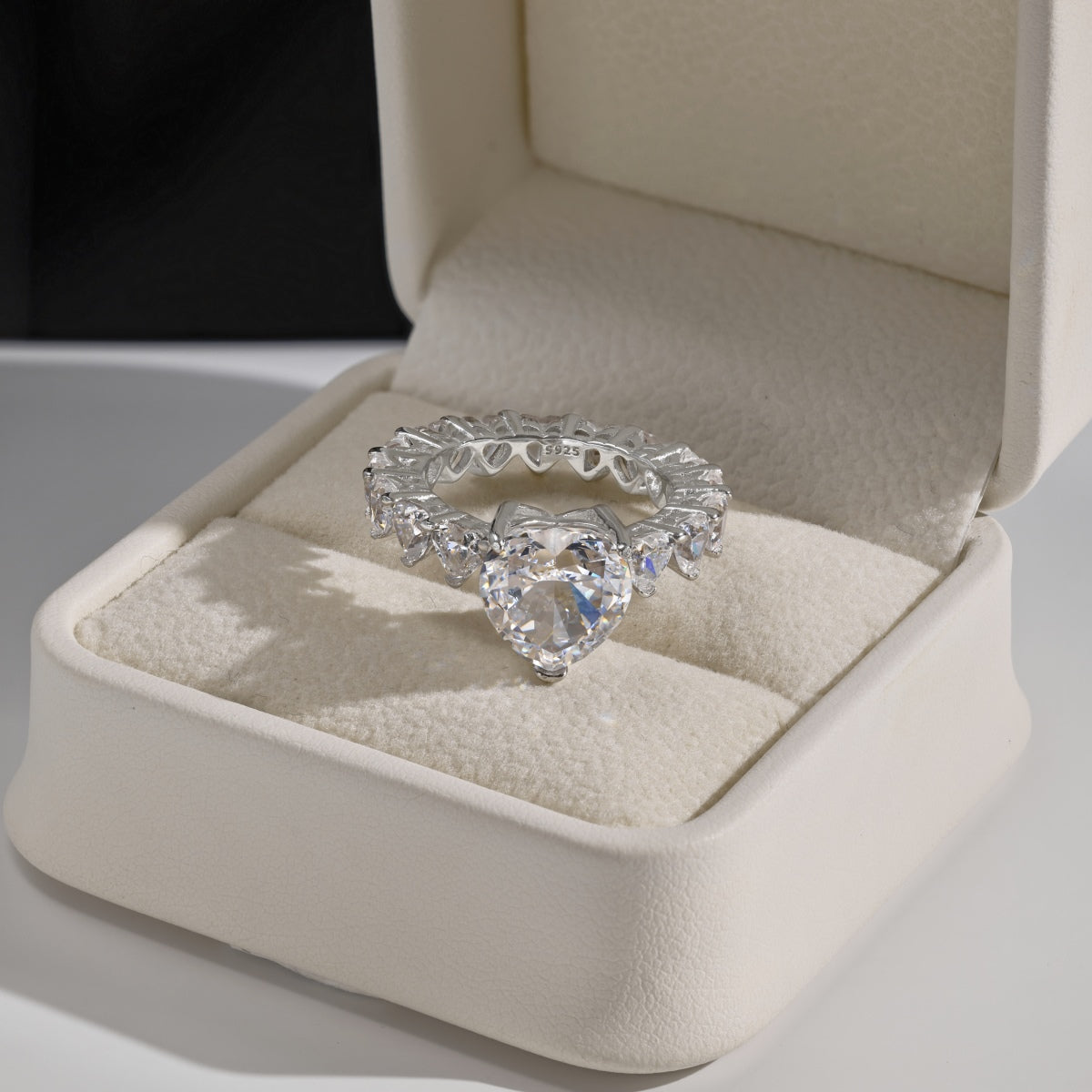 Heart-shaped diamond ring in a jewelry box on a light background