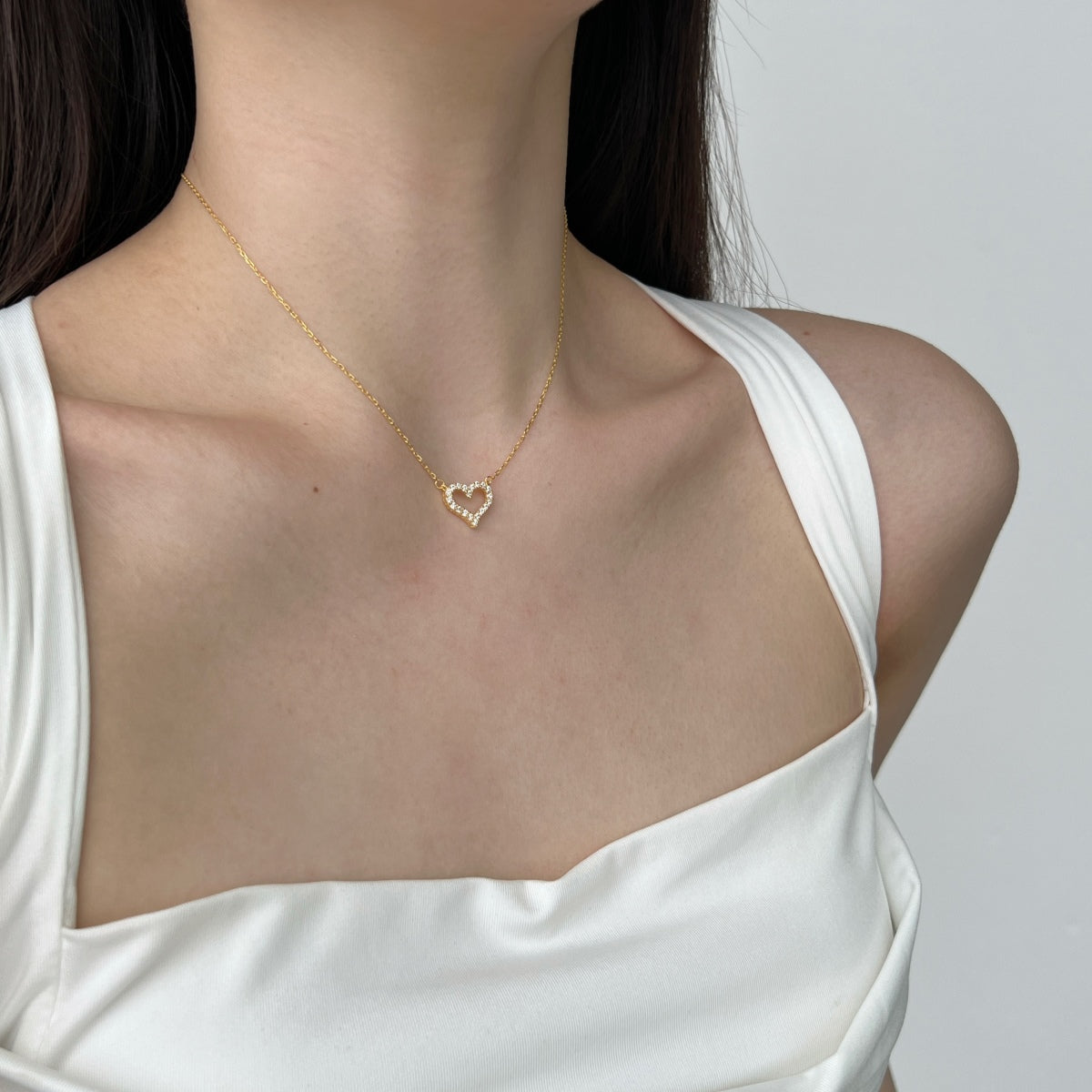 model wearing 18k gold heart pendant necklace with zircons