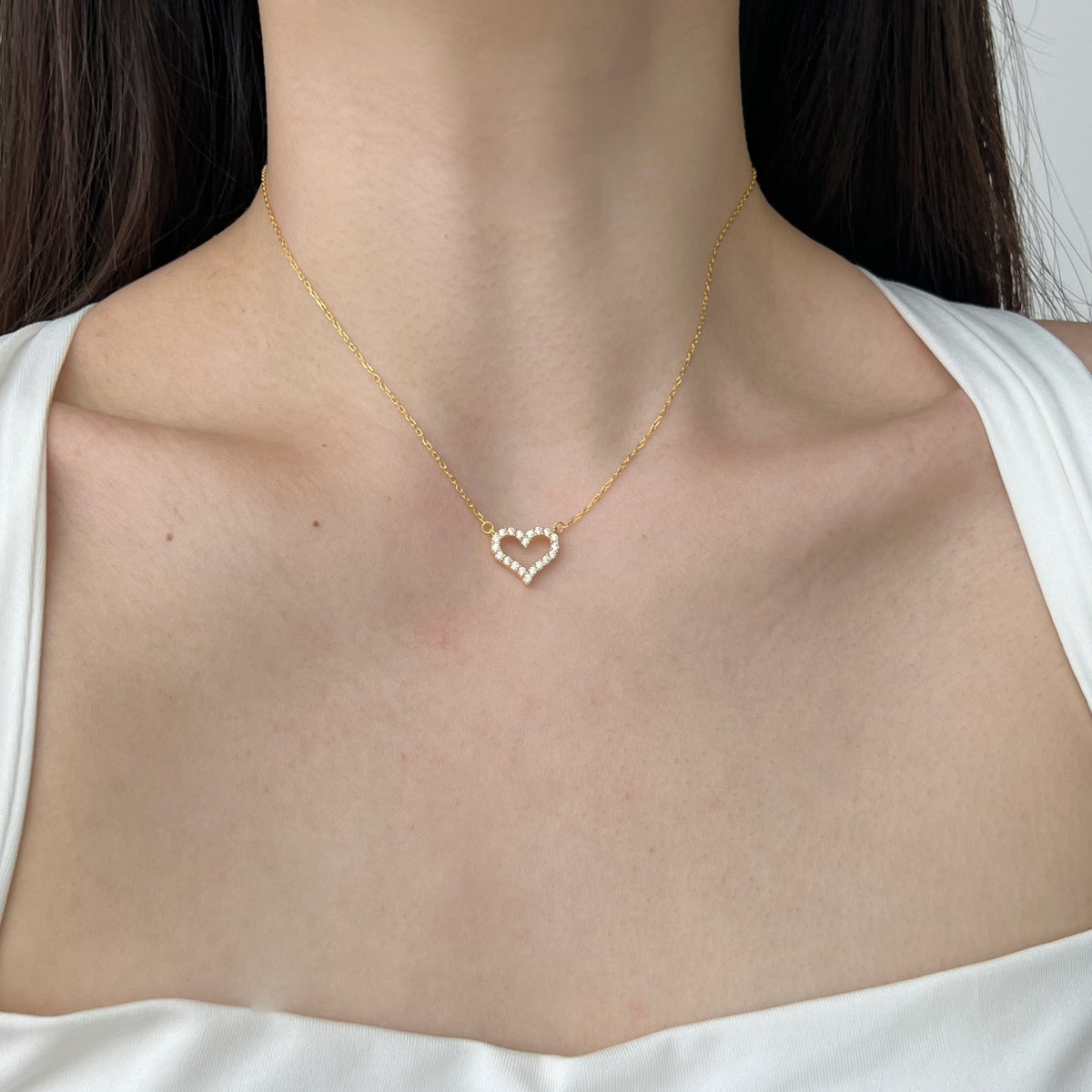 woman wearing 18k gold heart pendant necklace with zircons