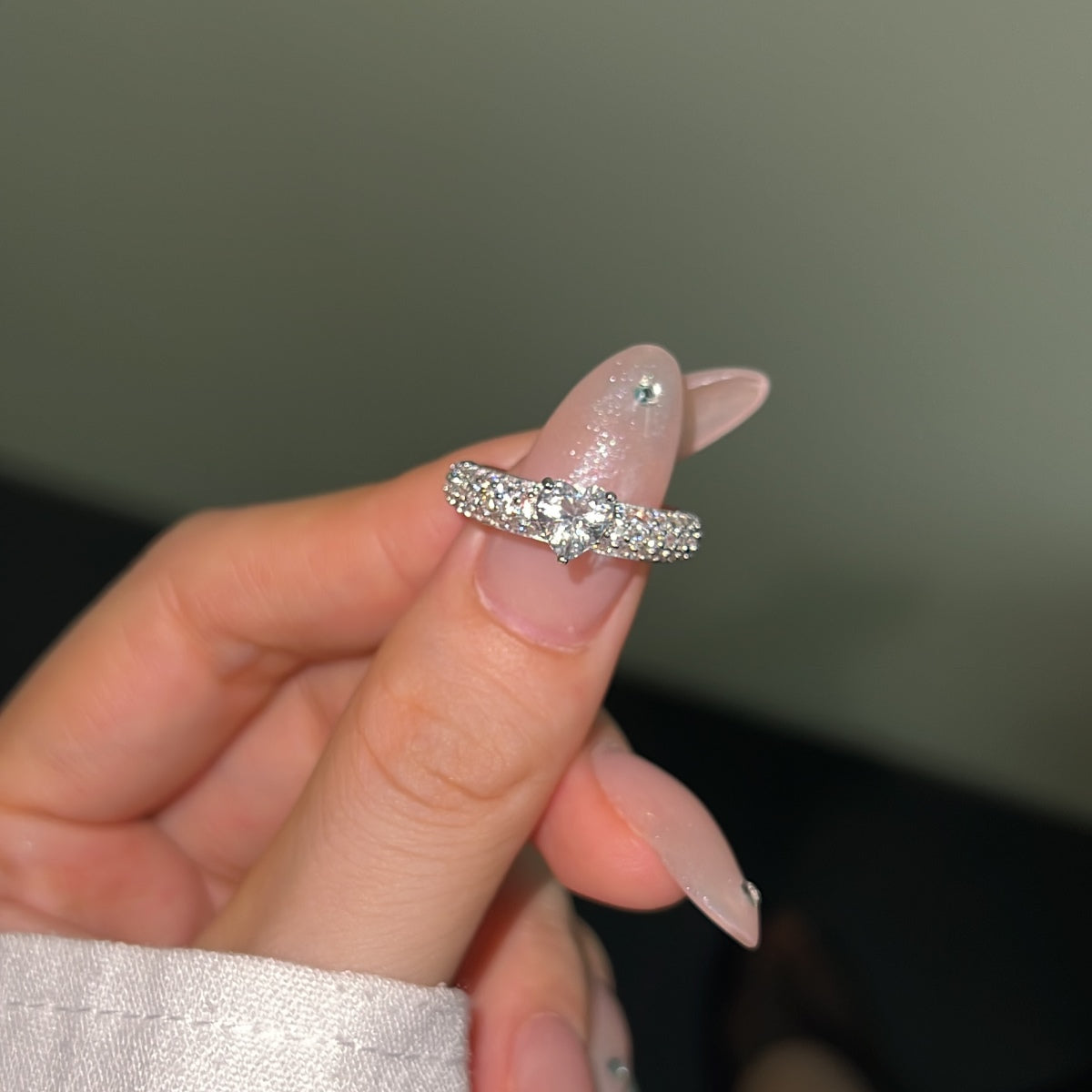 silver heart ring with zircon accents and chunky band on a thumb