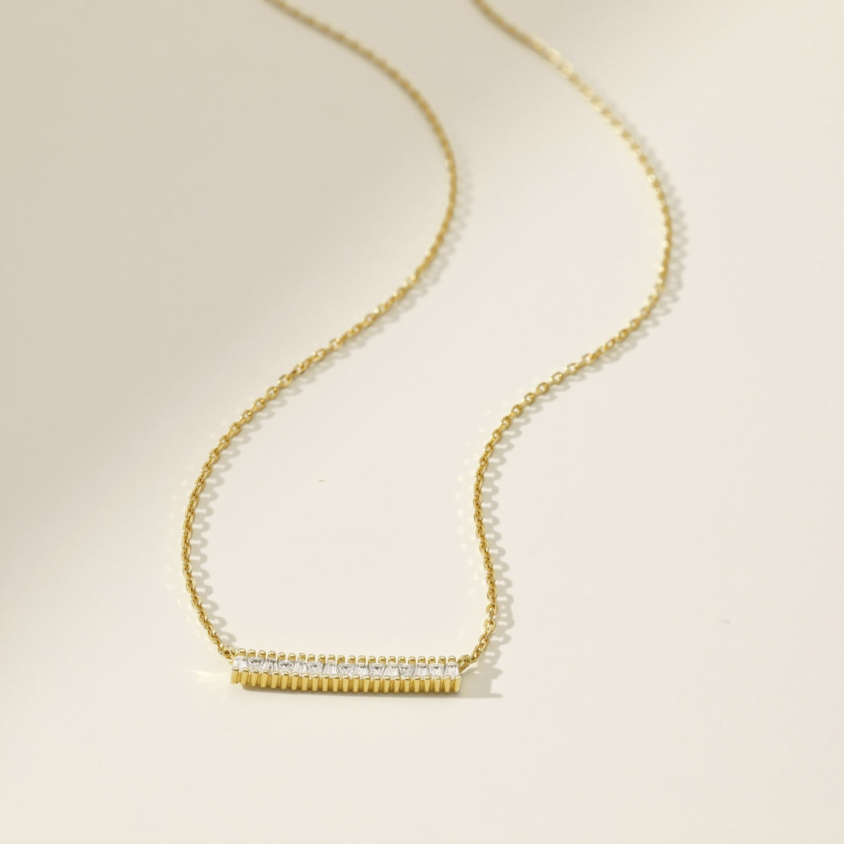 Gold necklace on a beige background