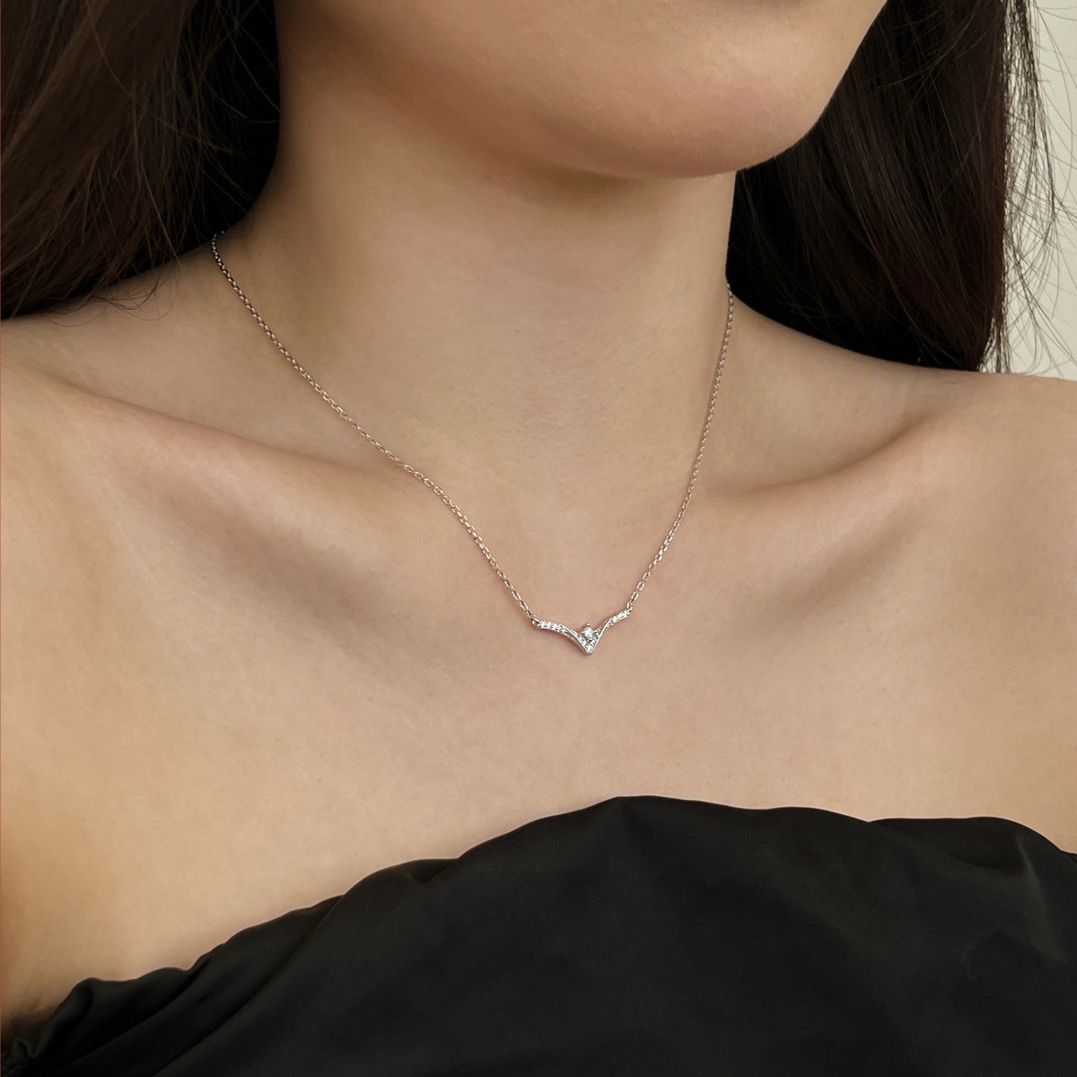 Necklace with a chevron pendant worn by a person