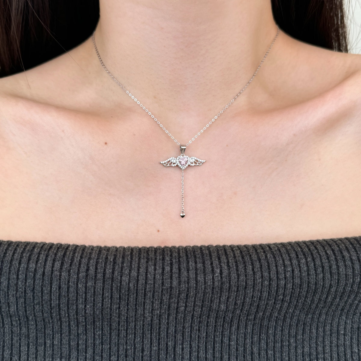 Silver necklace with a pendant worn by a person