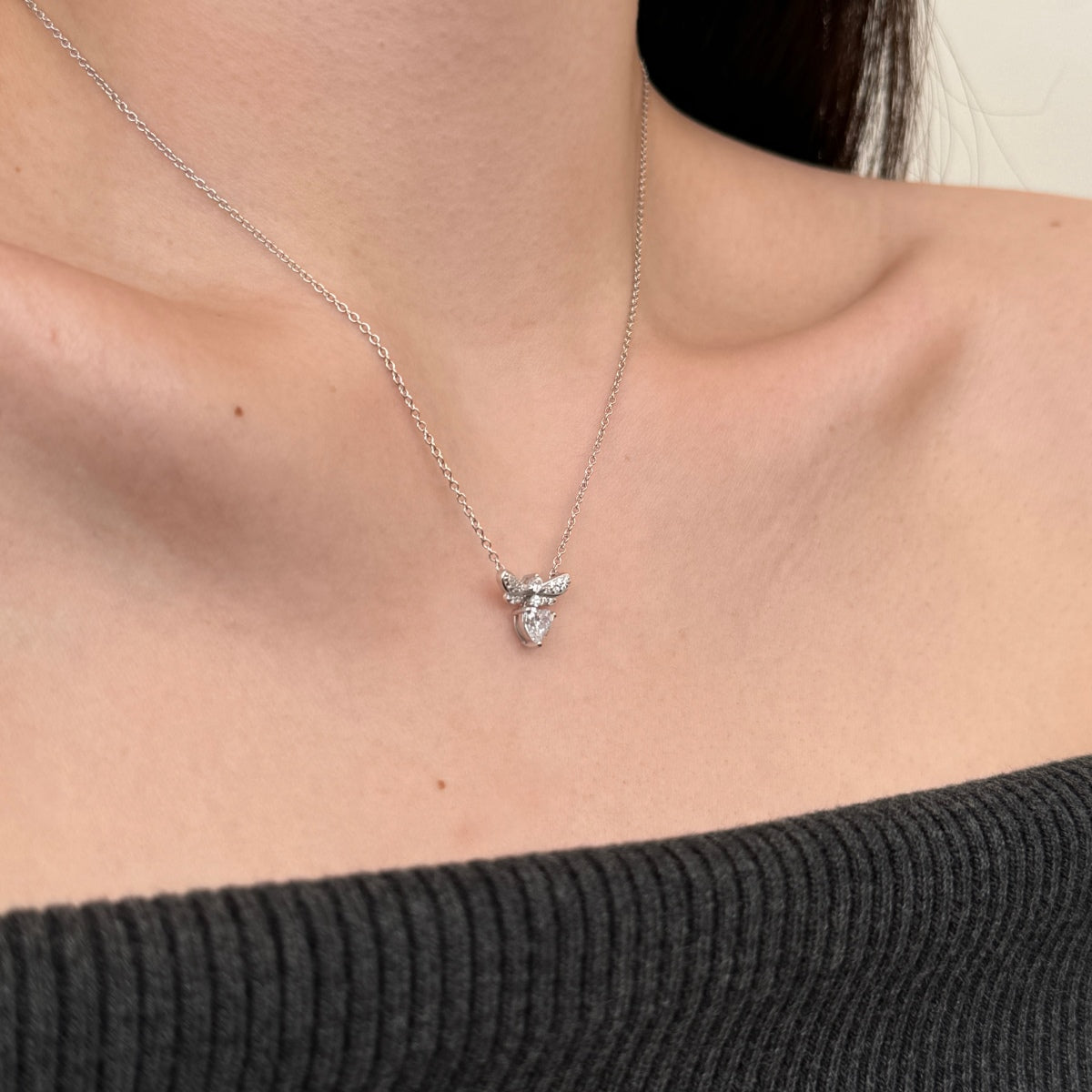 Necklace with a small pendant worn by a person