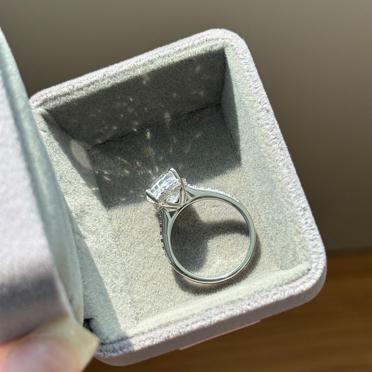 Silver ring with an oval diamond in a jewelry box