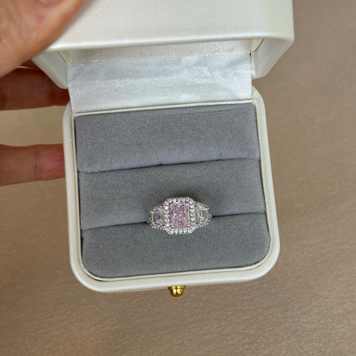 Pink diamond ring in a white box with gray interior