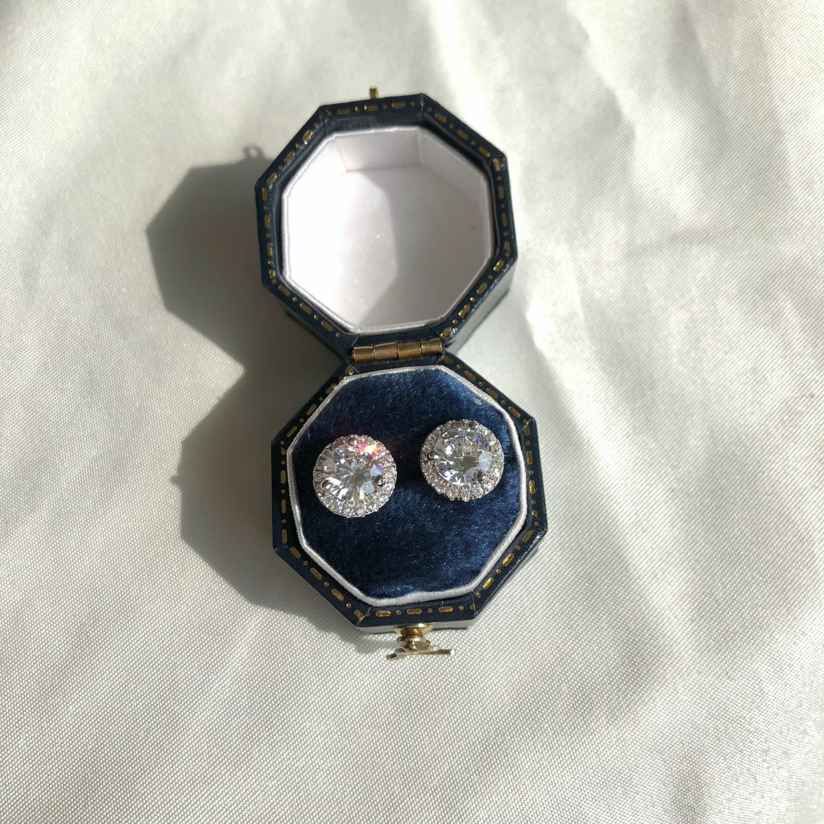 Elegant 925 sterling silver earrings with center round zircon and halo design in a blue earring box