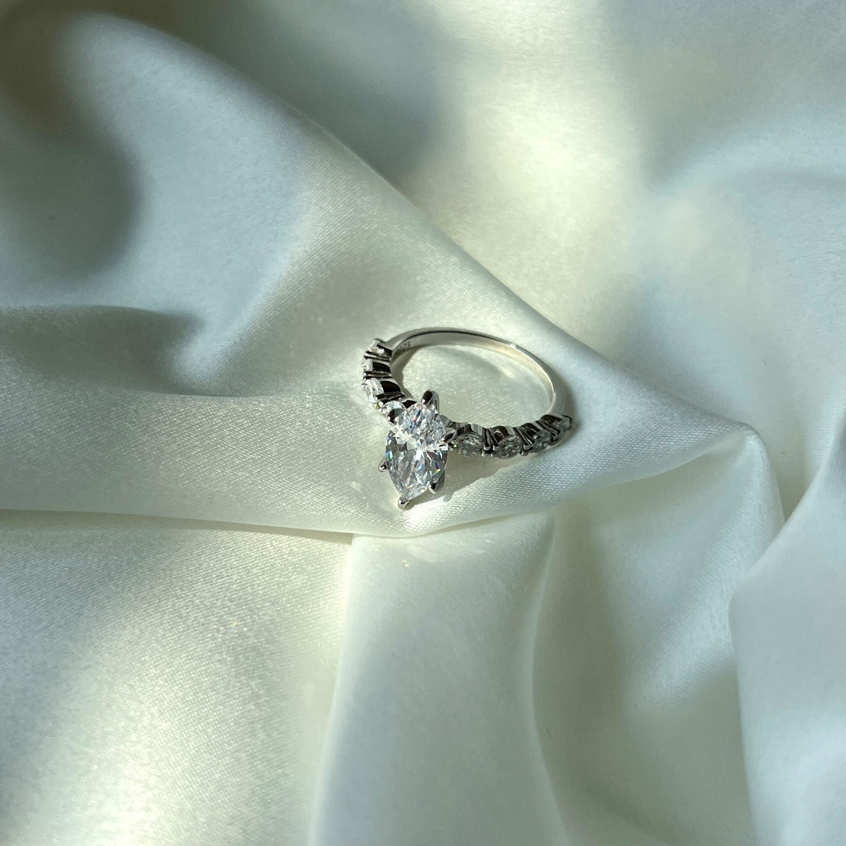 marquise Diamond ring on a soft white fabric background