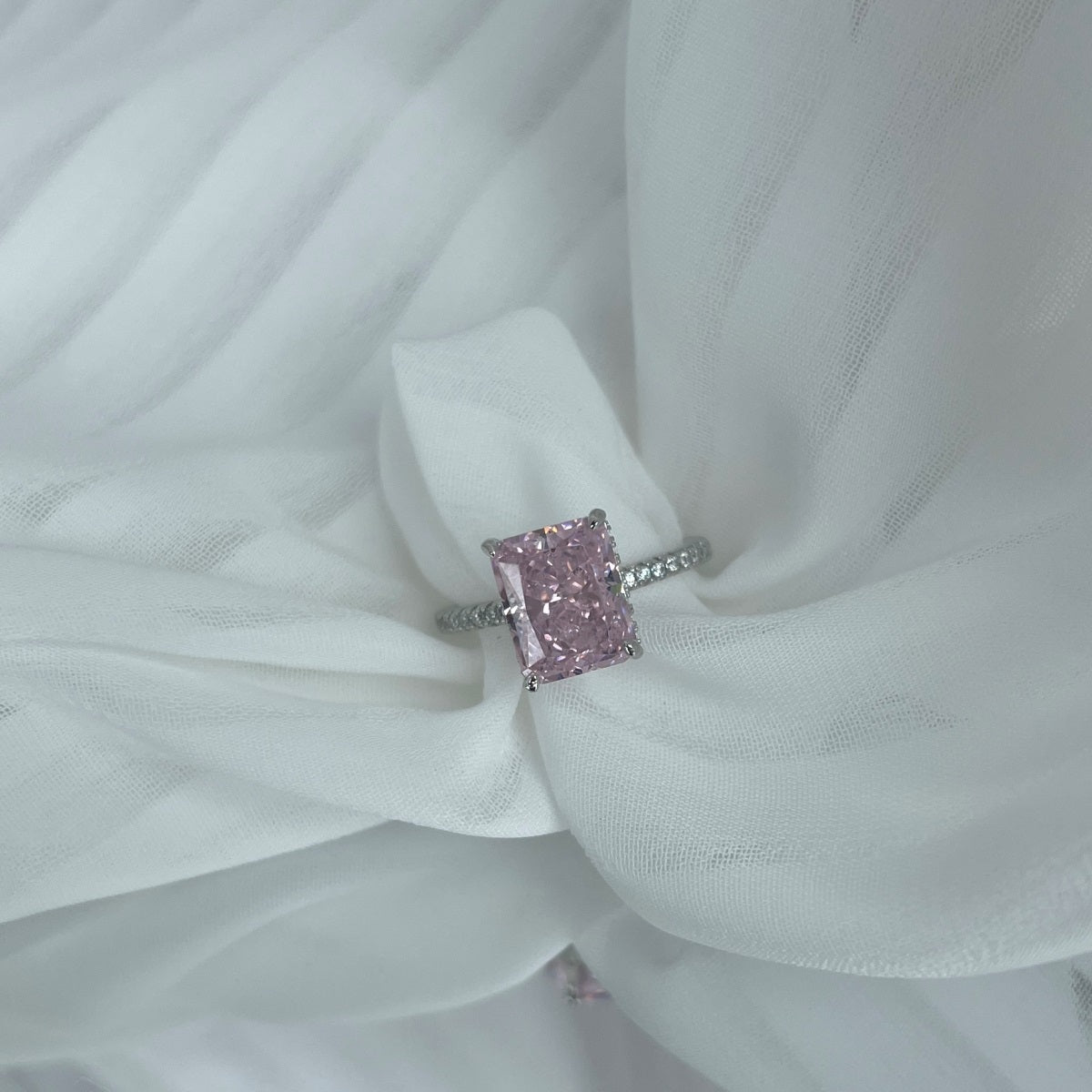 Ring with a pink gemstone on white fabric