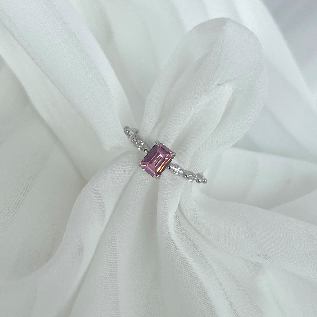 Pink gemstone ring on a white fabric background