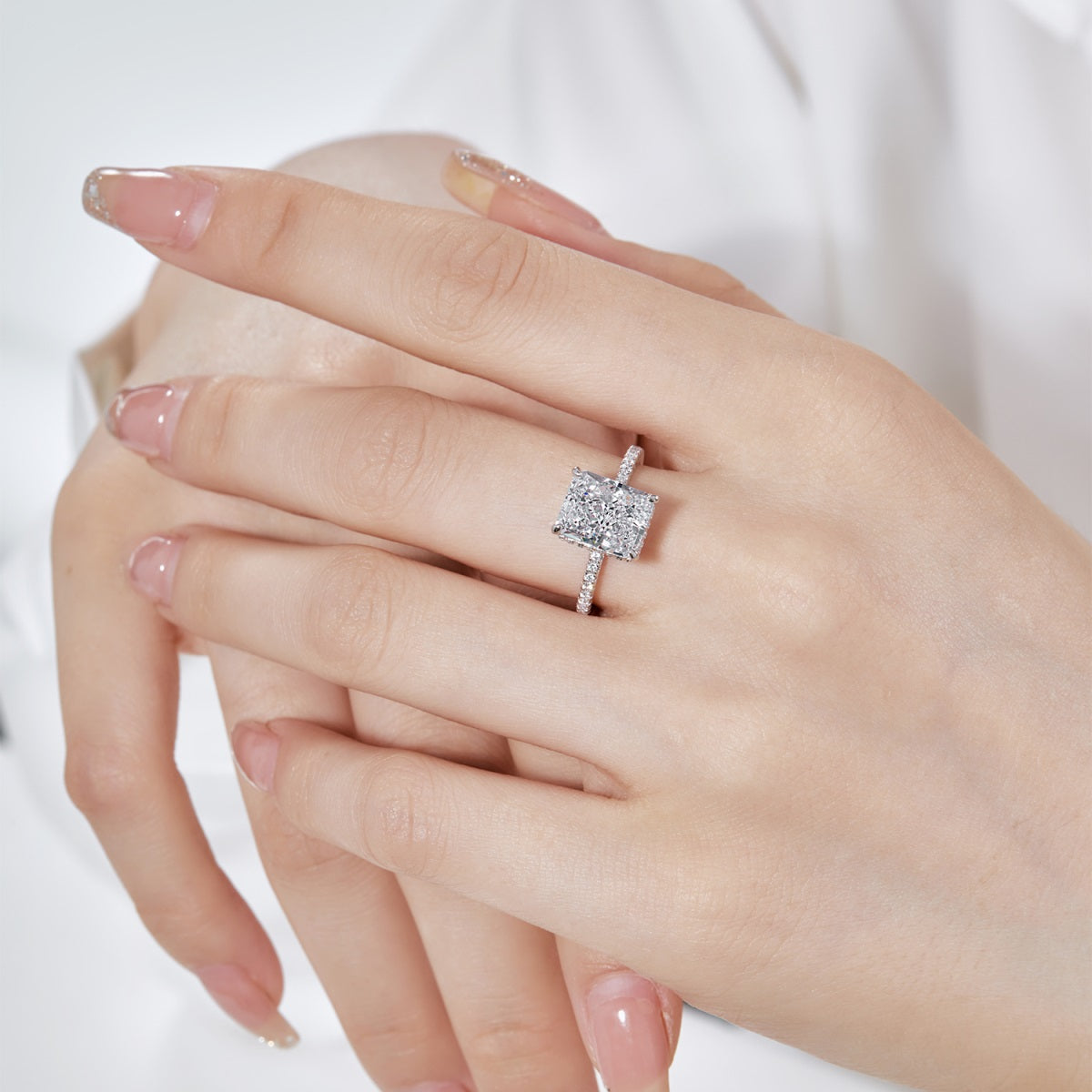 Silver ring with a diamond on a hand against a white background