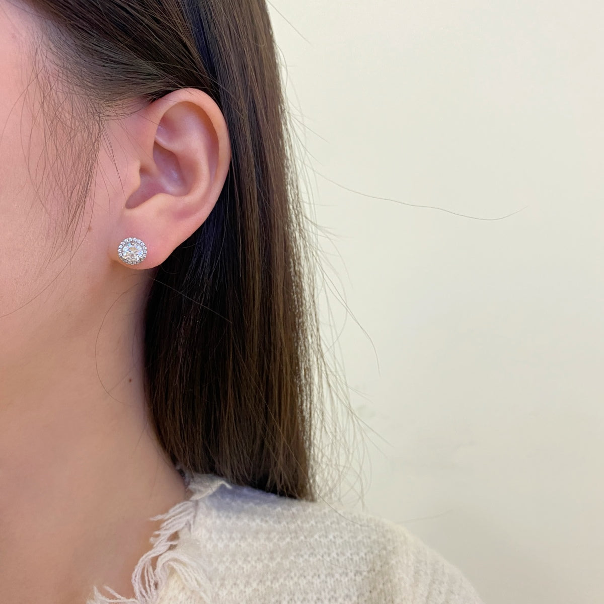 Dainty bridal zircon stud earrings with radiant halo setting shown on model